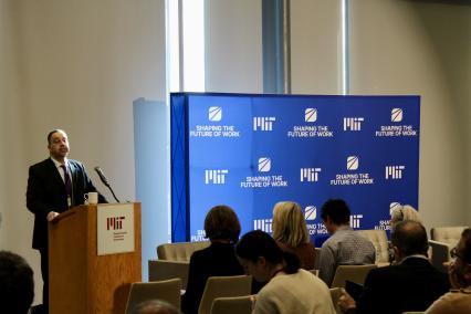Daron Acemoglu speaks from behind a podium at MIT