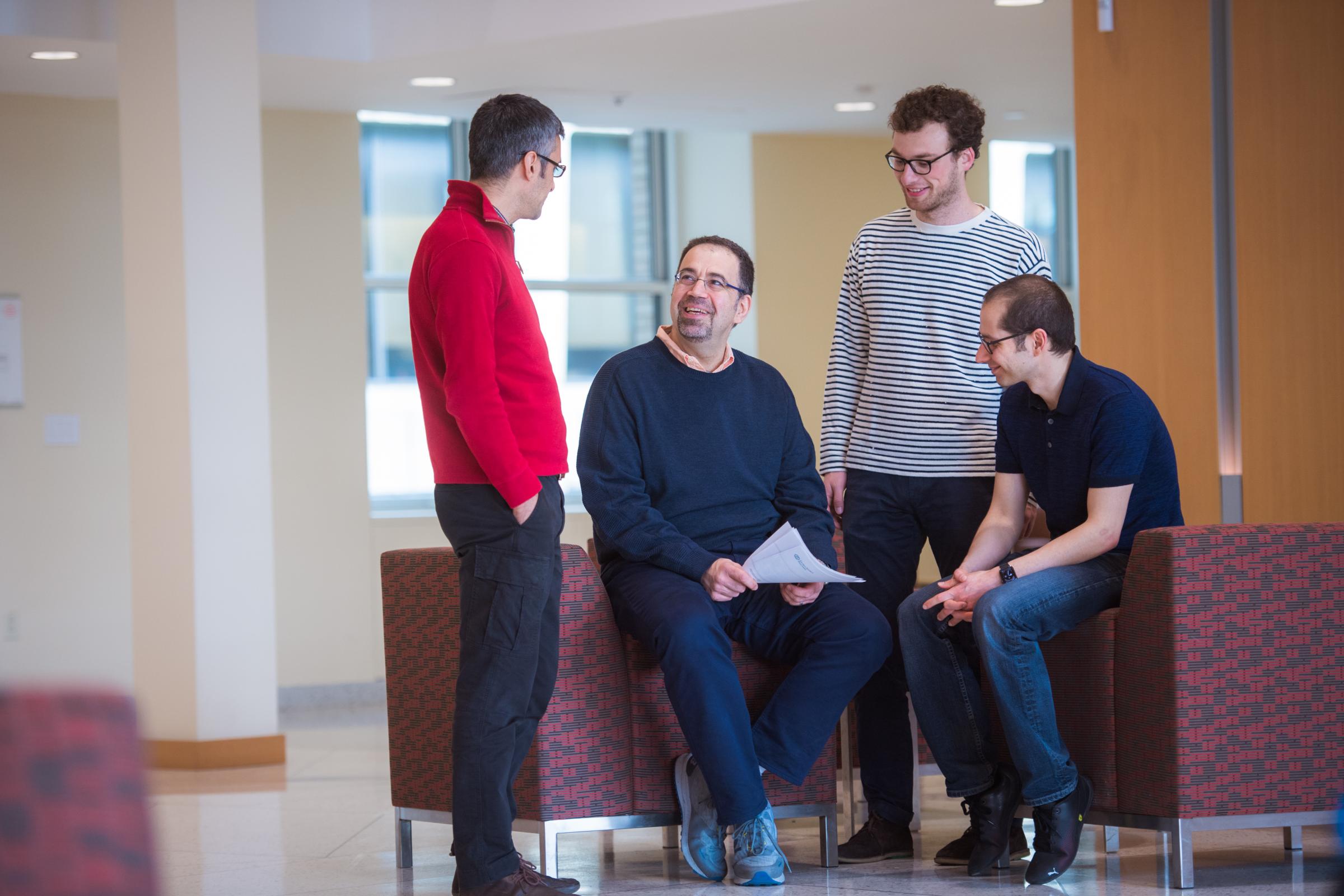 Daron Acemoglu with colleagues and grad students, photo by Gretchen Ertl