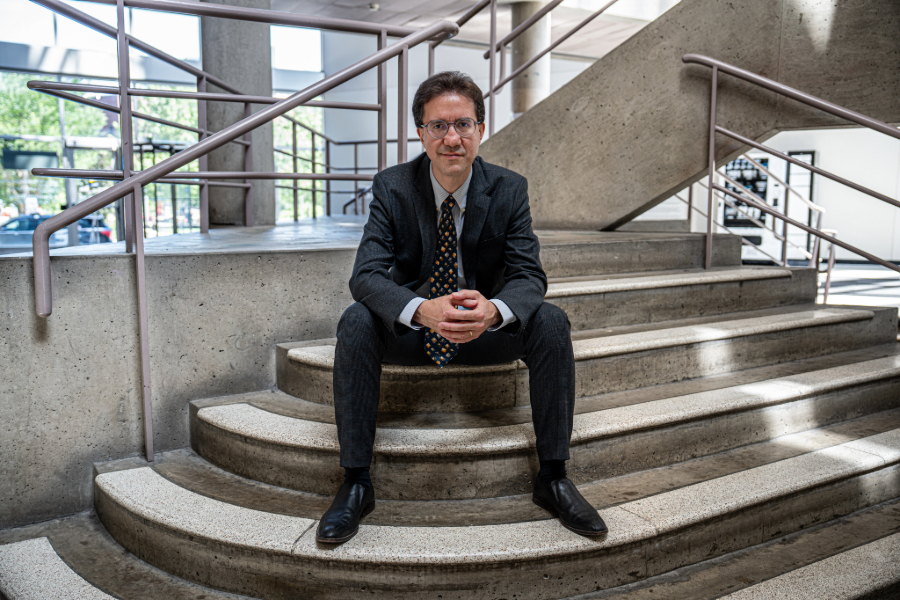 Davi Pinto sitting on concrete steps on MIT's campus