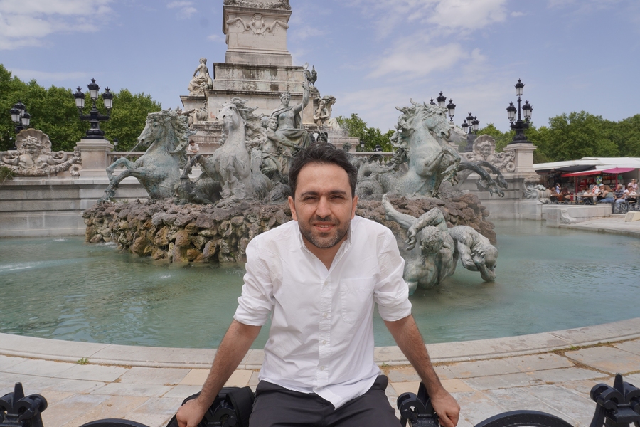 Gevorg Minasyan sitting in front of a fountain in Armennia.