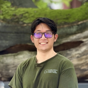 Picture of Eric Gao (former tree) standing in front of a tree.